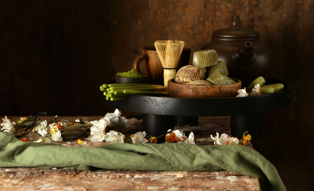 A bowl of kitchen ingredients beside a teapot