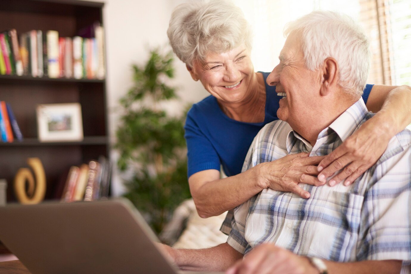 Two people at home using a laptop for an online consultation